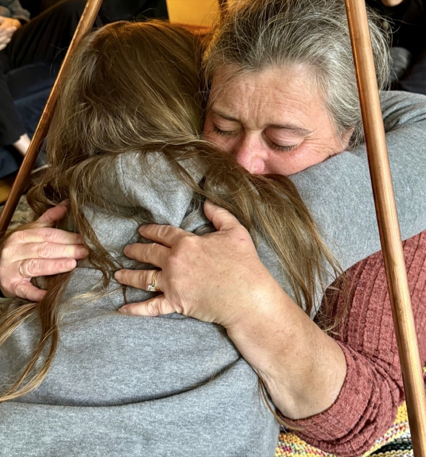 Two retreat participants holding each other in a long, emotional hug